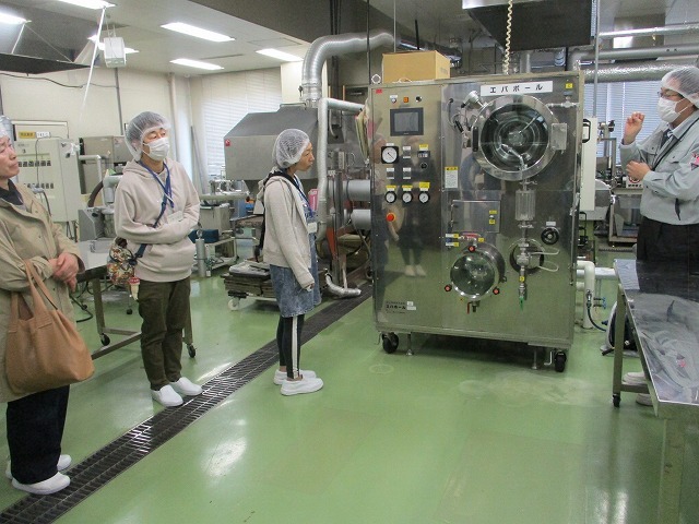 食品加工研究センターで、加工施設・機械の説明を受ける様子