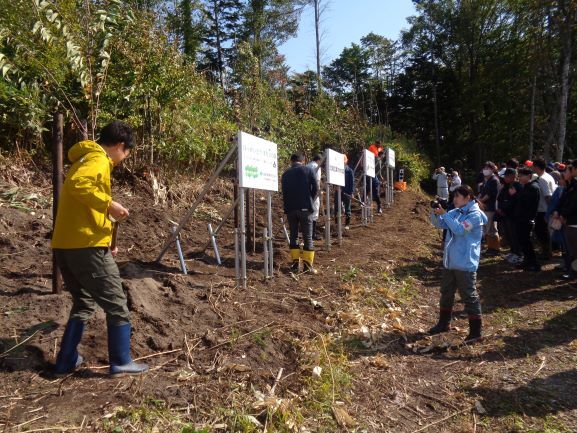 ・各社が立てた看板前での植樹