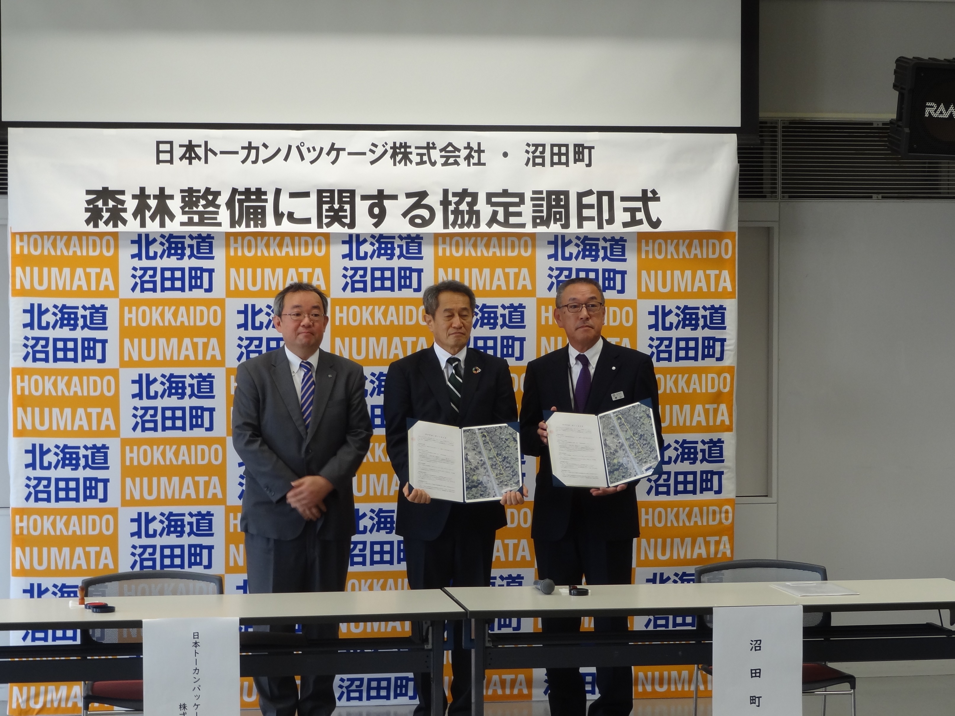 協定書の署名後の写真撮影　（左）空知総合振興局　宮森副局長（中）梶原専務（右）横山町長