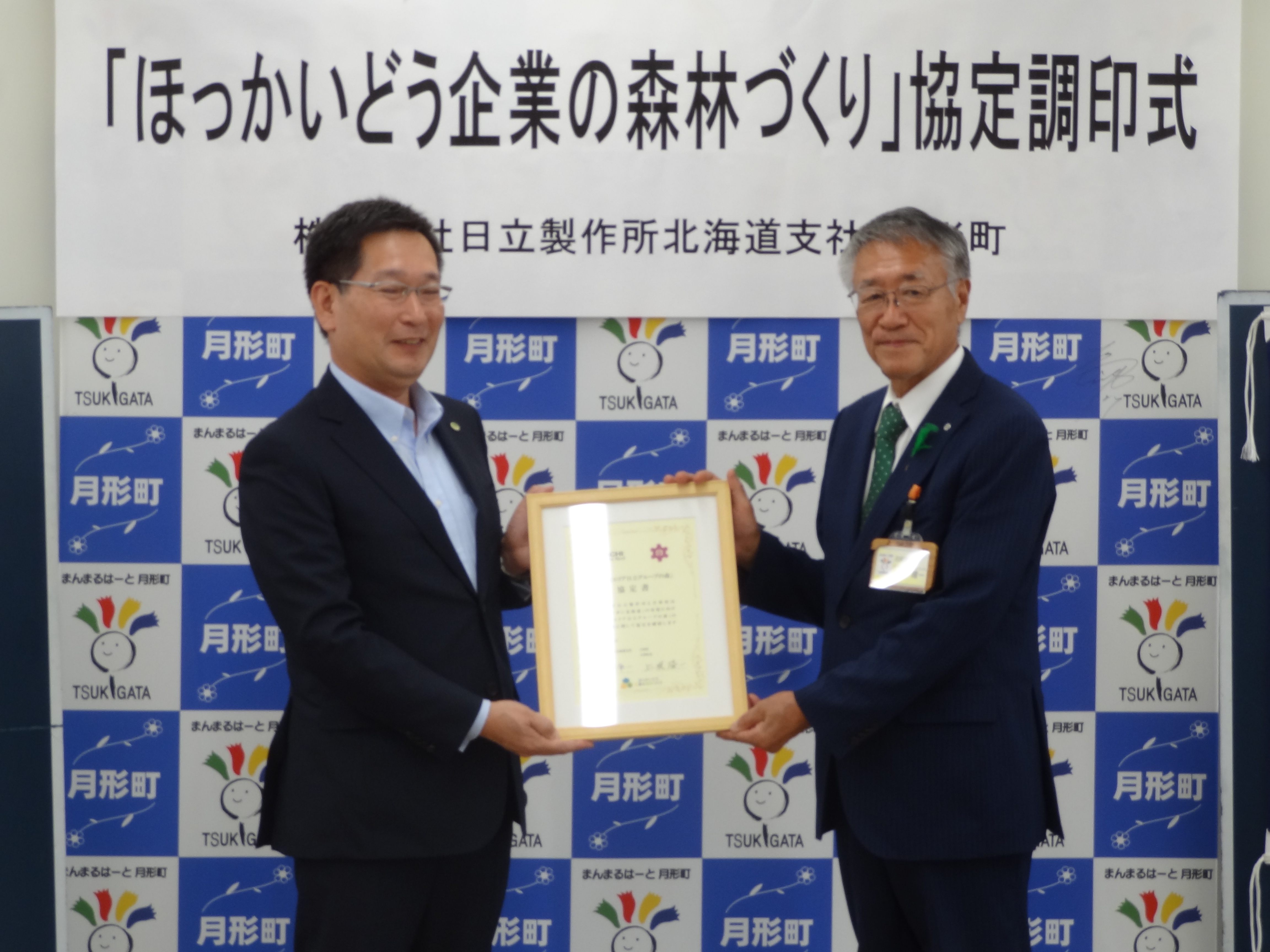 今給黎支社長（左）と上坂月形町長（右）との間で、協定書の署名の取り交わしが行われました。